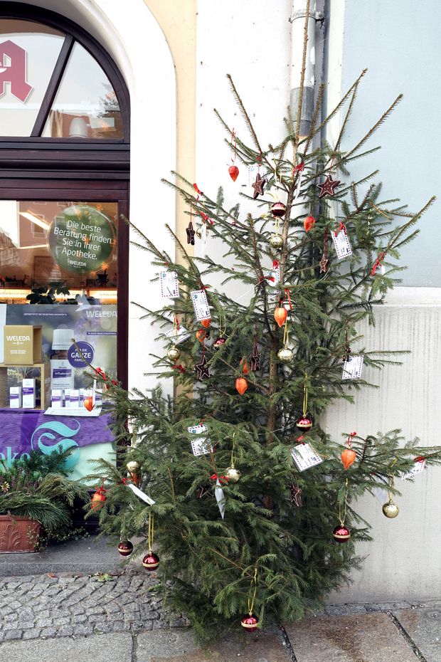 Geschmückter Weihnachtsbaum an Hausecke