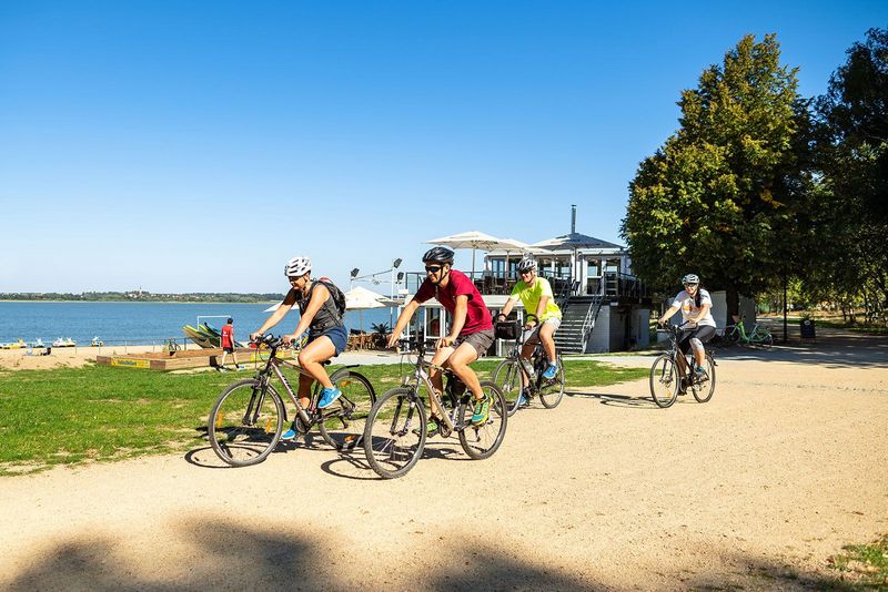 Vordergrund eine Gruppe Radfahrer, Hintergrund Stausee Bautzen