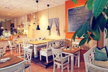 Blick in das Nähcafe Lotte – Tischgruppen in weiß/braun im Landhausstil. 