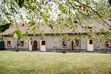 langes Haus, holzverkleidet, mit rotem Spitzdach