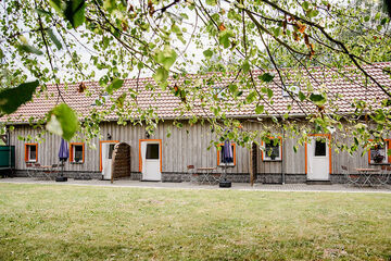 langes Haus, holzverkleidet, mit rotem Spitzdach