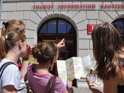 Jugendliche stehen mit einem Stadtplan vor der Bautzener Tourist-Information