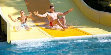 Zwei Männer rutschen die Rutsche des Spreeebades runter