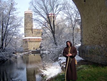 Mann in Mönchskutte steht unter Brückenbogen im Hintergrund die Alte Wasserkunst