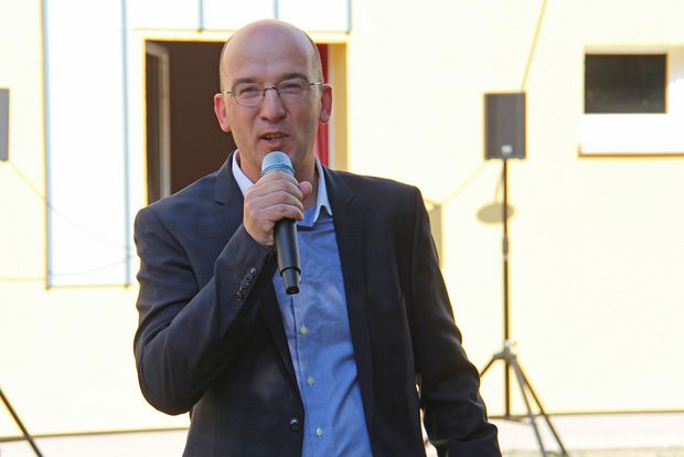 Mann hält Mikrofon in der Hand und redet