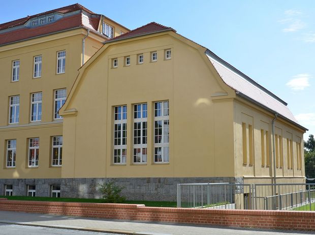 Mättig Grundschule- gelbes Gebäude mit kleiner Wiese davor