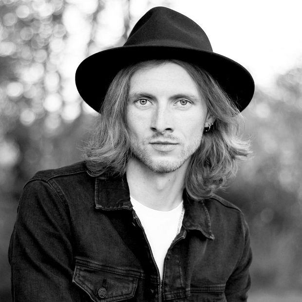 Schwarz-weiß-Foto: Junger Mann mit Hut