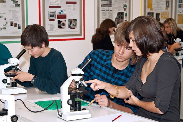 Schiller Gymnasium Drei Schüler führen ein biologisches Experiment, mit Mikroskop durch