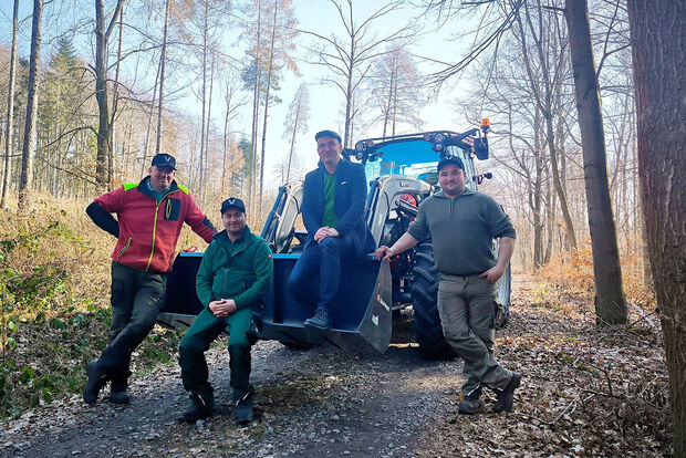 Forstschlepper vier Männer am Forstschlepper im Wald
