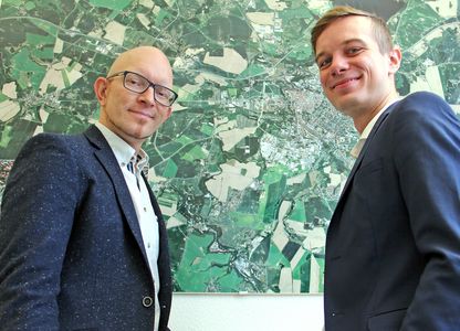 Andreas Schwerin (r) mit Wirtschaftsförderer Alexander Scharfenberg stehen vor dem Stadtplan von Bautzen