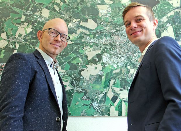 Andreas Schwerin (r) mit Wirtschaftsförderer Alexander Scharfenberg stehen vor dem Stadtplan von Bautzen 