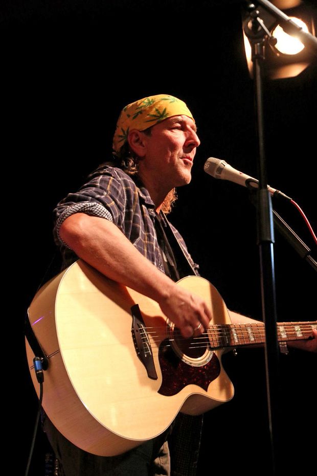 Andreas Schirneck Mann in kariertem Hemd singt und spielt Gitarre