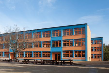 Abendoberschule- blau-orangenes Gebäude, im Vordergrund- Sitzbänke