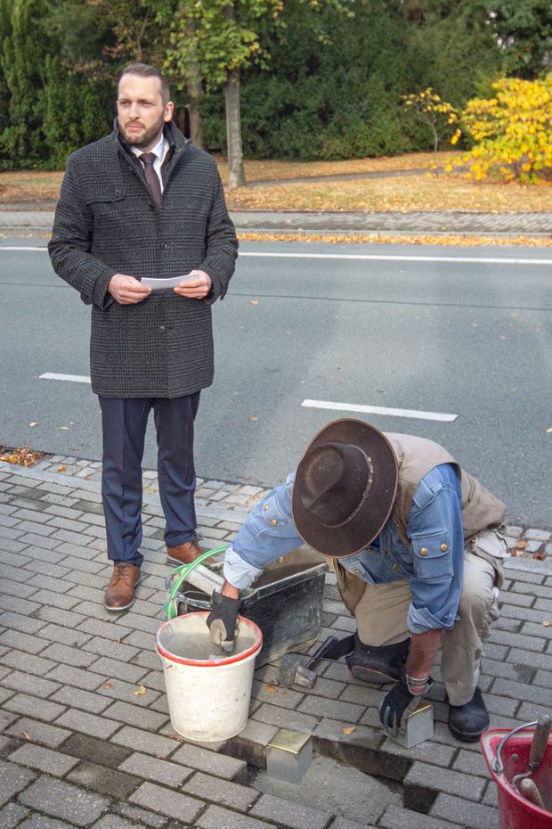 Verlegung der Stolpersteine Gunter Demnig verlegt Stolpersteine, im Hintergrund Bürgermeister Heiko Nowak