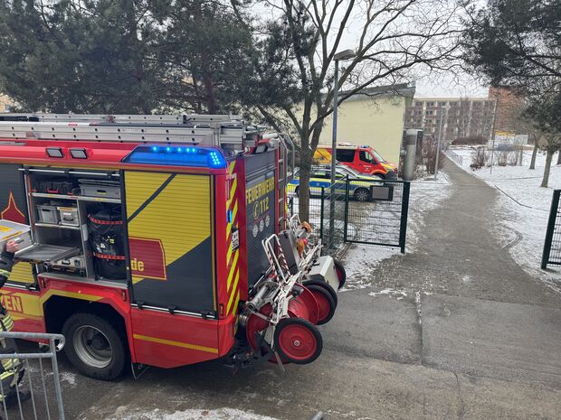 Ein Löschfahrzeug der Feuerwehr steht vor einer Oberschule.