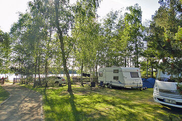 Wohnwagenstellplätze und Zeltwiese, See im Hintergrund