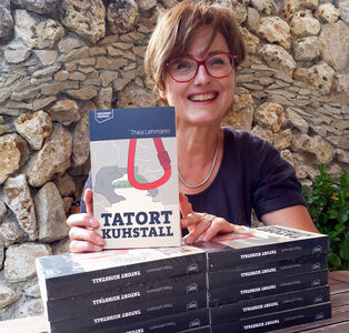 Autorin Thea Lehmann Thea Lehmannsteht vor einer Steinwand und hält Buch in der Hand
