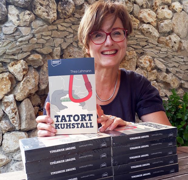 Autorin Thea Lehmann Thea Lehmannsteht vor einer Steinwand und hält Buch in der Hand