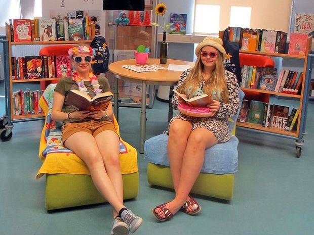 Zwei jugendliche Leserinnen im sommerlichen Outfit präsentieren die Bücher für den Buchsommer.