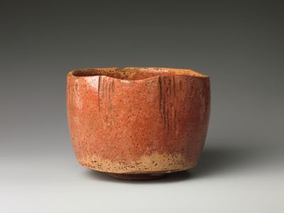 Kleiner Becher aus Ton mit orangem, glänzendem Überzug. Nach japanischem Vorbild.