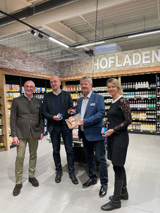 Hofladen im Marktkauf vier Personen stehen im Hofladen und halten regionale Produkte in der Hand