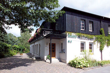 großes weißes Haus mit dunkler Hausverkleidung im Obergeschoss