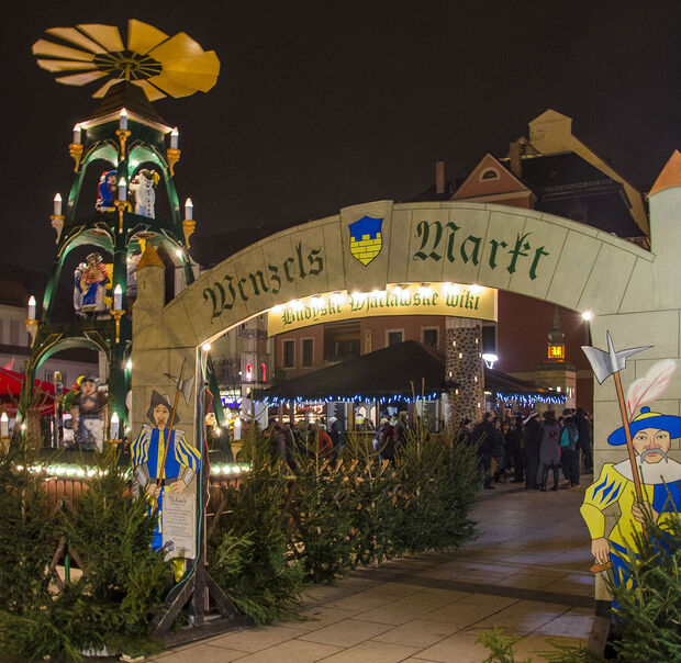 Der Eingangsbogen zum Wenzelsmarkt. Dahinter steht eine große beleuchtete Pyramide.