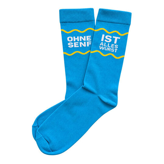 türkisfarbene Socken mit geteiltem Spruch am Schafft, eine Socke weißer Text: Ohne Senf, andere Socke weißer Text: ist alles Wurst, über und unter dem Spruch ist eine gelbe Wellenlinie