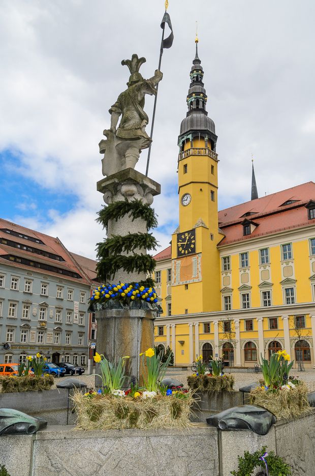 Osterbrunnen vor dem Rathaus, geschmückt mit Plasteostereiern, Narzissen und kleinen Stiefmütterchen