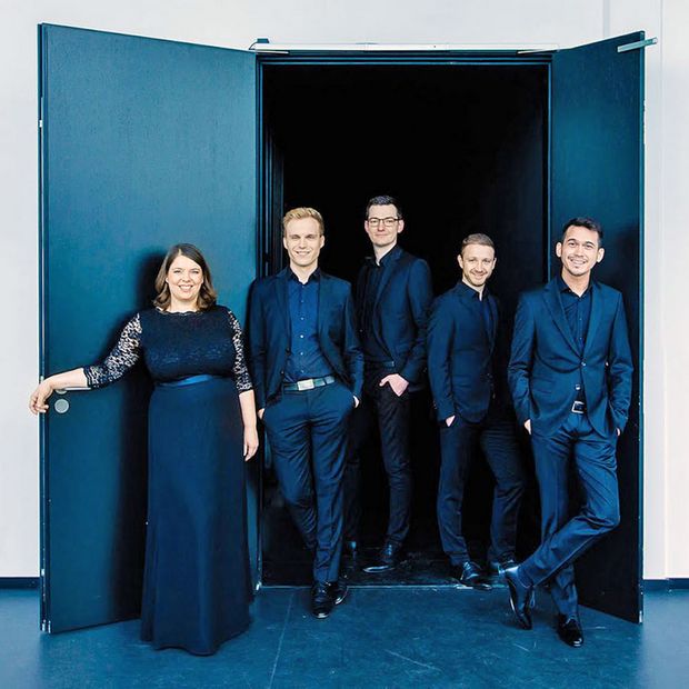 Fünf schwarz gekleidete Personen vor einer schwarzen Tür