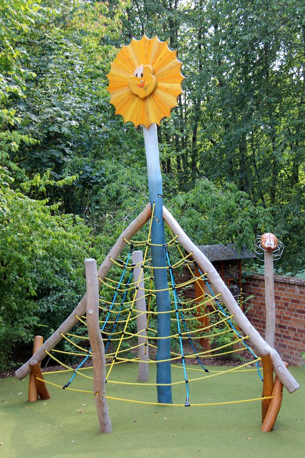Bunter Spielplatz mit lachender Sonne an der Spitze