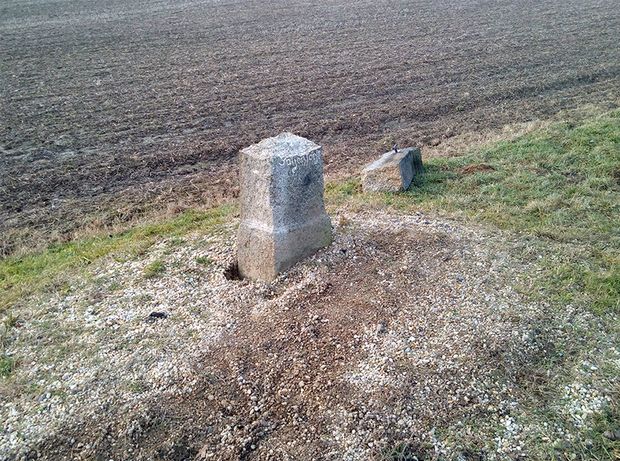 defektes Betkreuz liegt auf Wiese